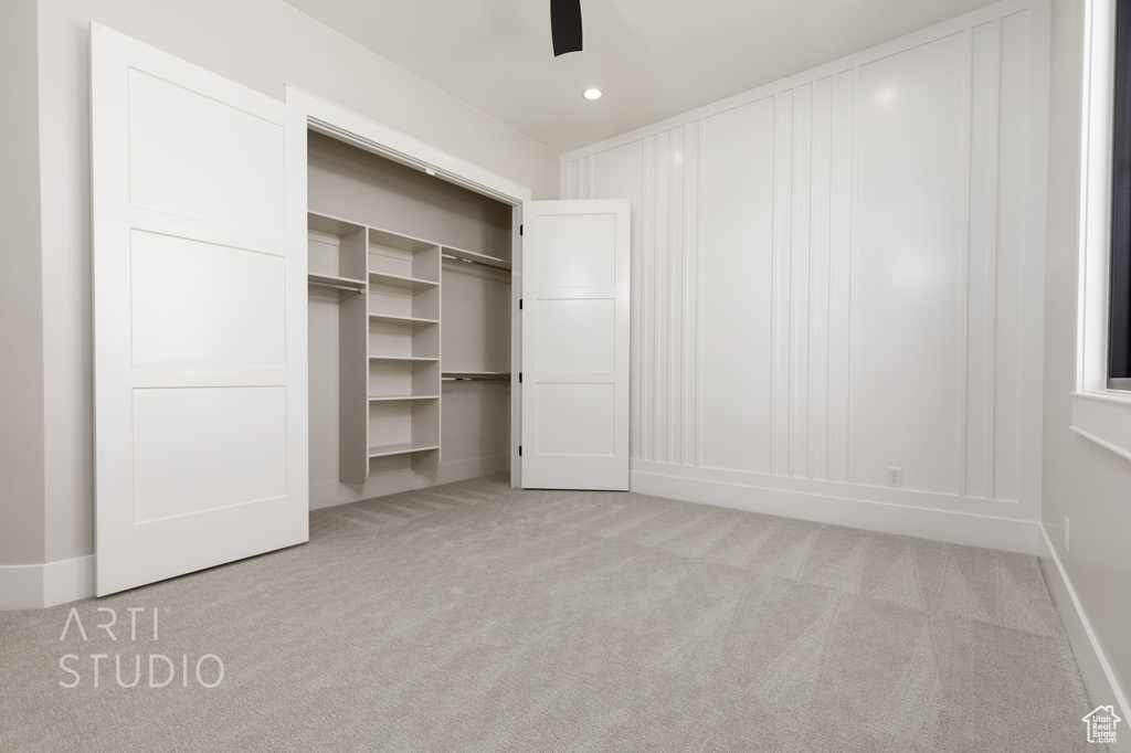 Unfurnished bedroom with a closet, ceiling fan, and carpet floors