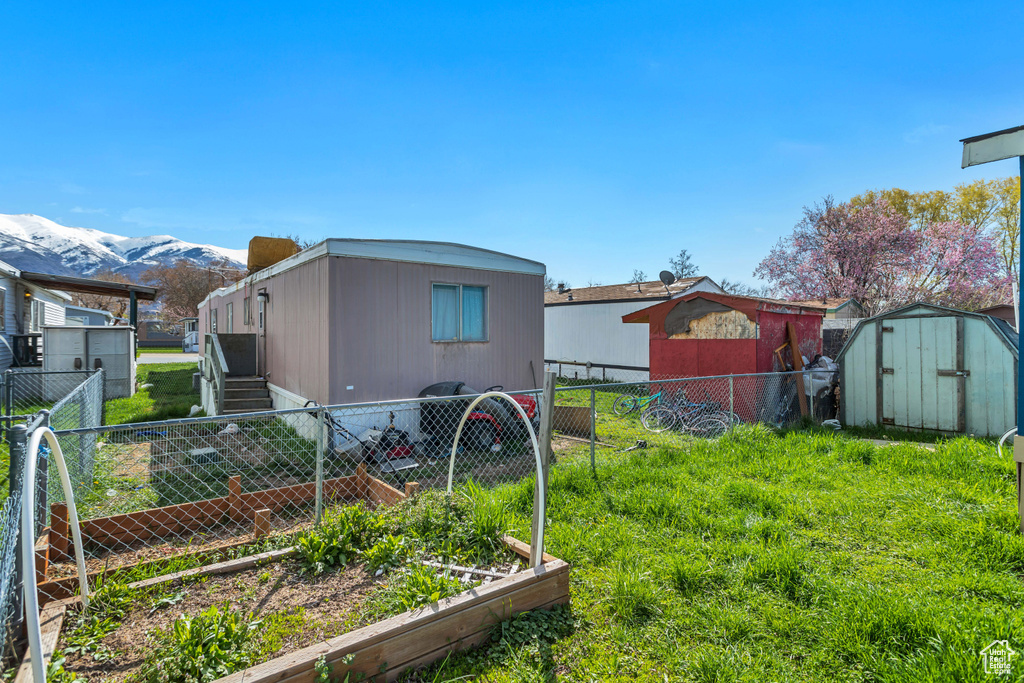 View of yard with a mountain view and a storage shed