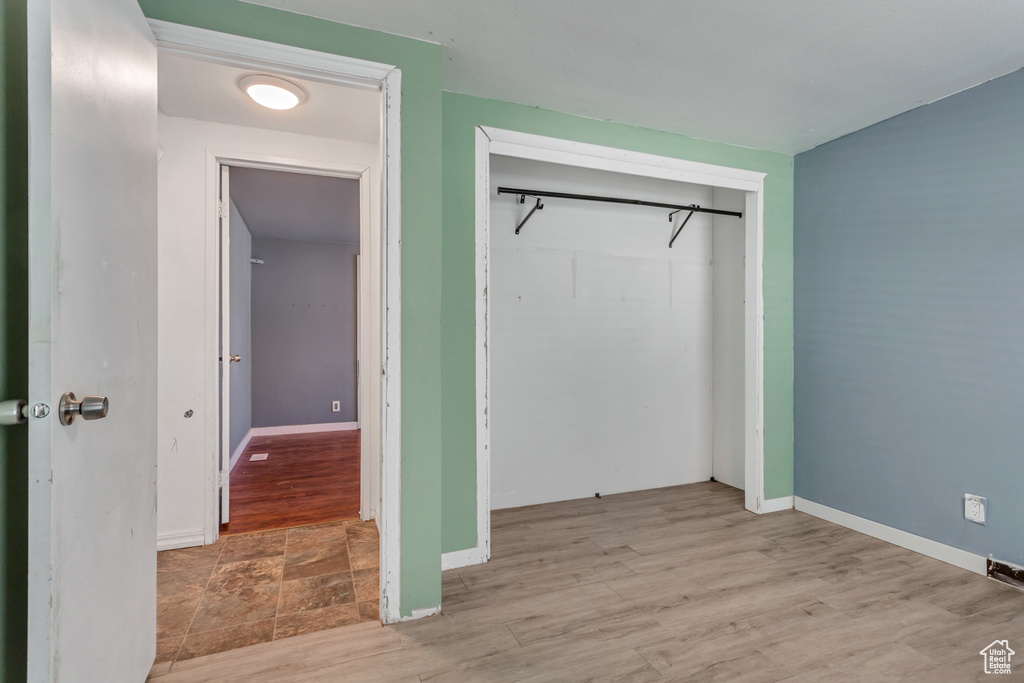 Unfurnished bedroom featuring tile flooring and a closet