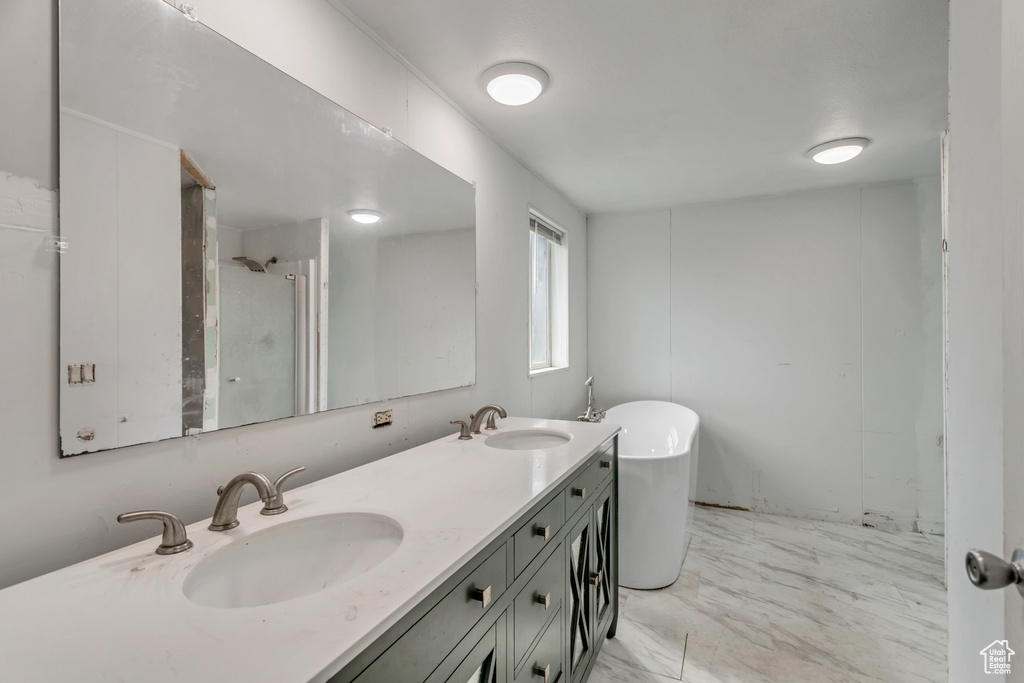 Bathroom featuring double vanity, tile flooring, and plus walk in shower