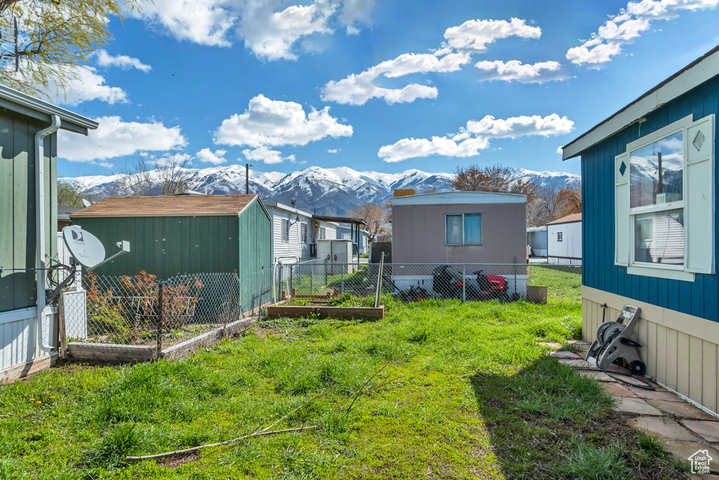 View of yard featuring a mountain view and a storage shed