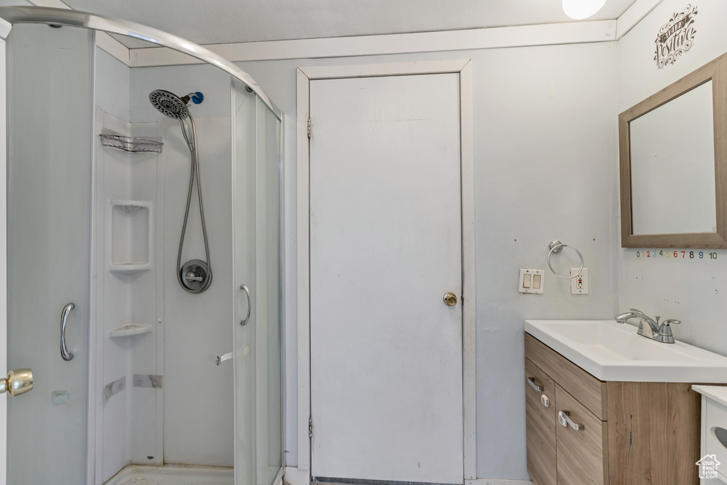 Bathroom featuring oversized vanity and a shower with shower door