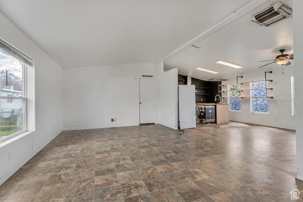 Unfurnished living room featuring ceiling fan and tile floors