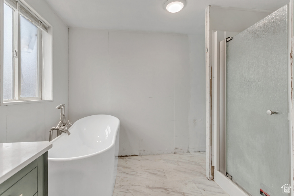 Bathroom featuring separate shower and tub, vanity, and tile flooring