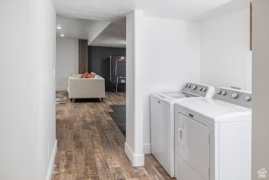 Clothes washing area featuring independent washer and dryer, hardwood / wood-style flooring, and hookup for a washing machine