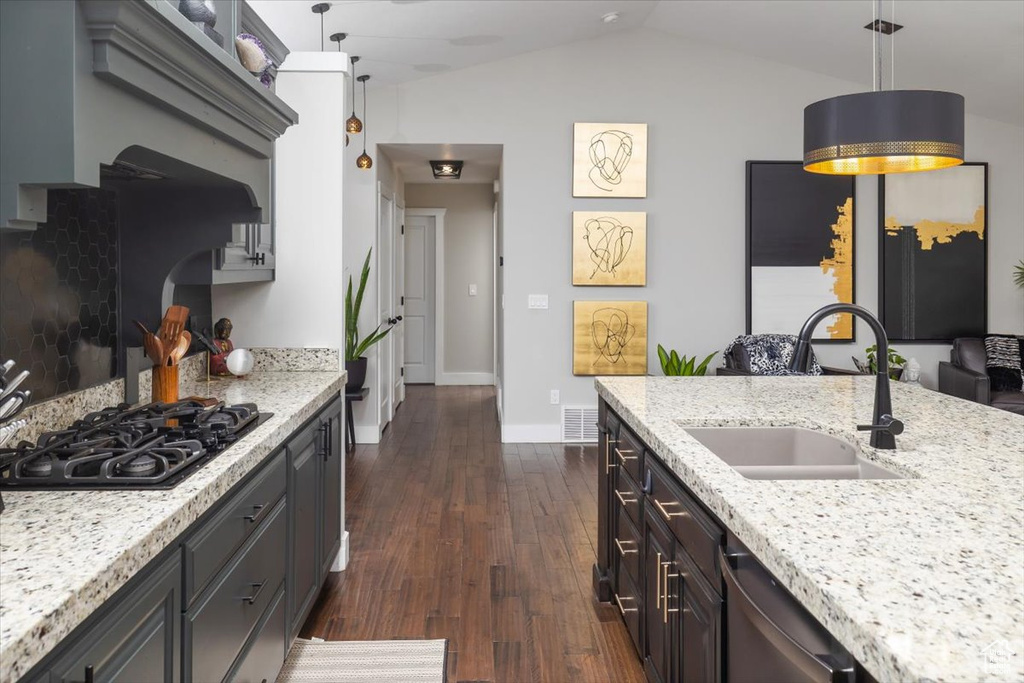 Kitchen featuring black gas cooktop, dark hardwood / wood-style flooring, lofted ceiling, sink, and pendant lighting