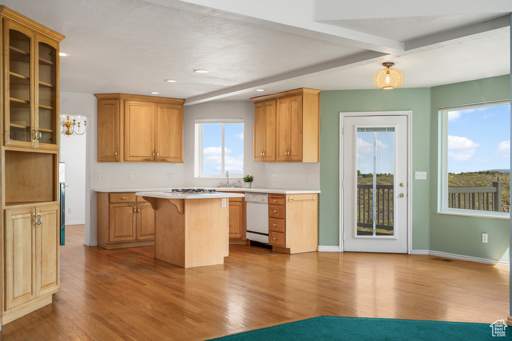 Kitchen with a kitchen island, a kitchen breakfast bar, and light hardwood / wood-style floors