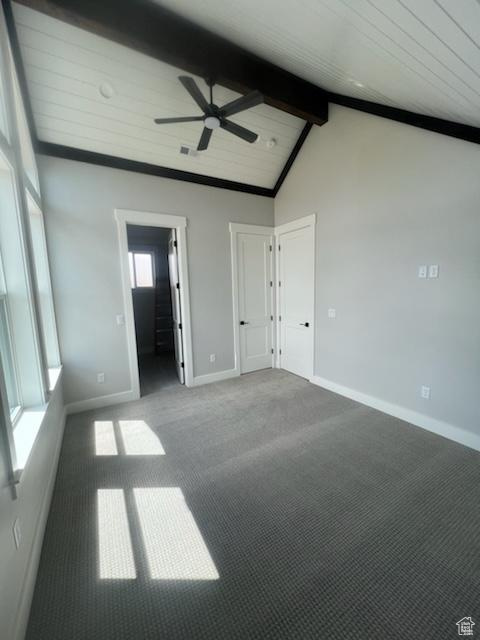 Empty room featuring high vaulted ceiling, beam ceiling, ceiling fan, and carpet floors
