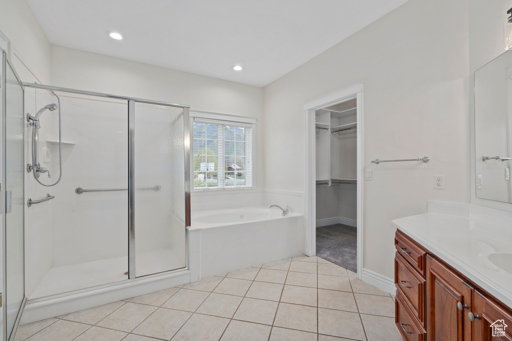 Bathroom featuring independent shower and bath, tile flooring, and vanity