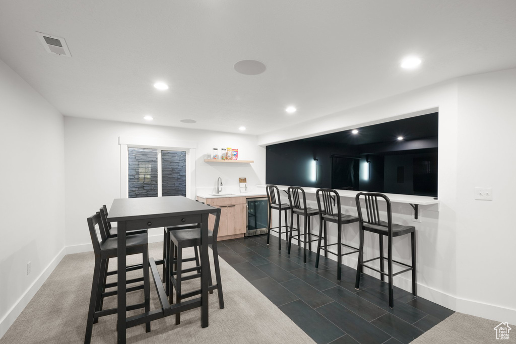 Dining area with sink, wine cooler, and dark tile floors