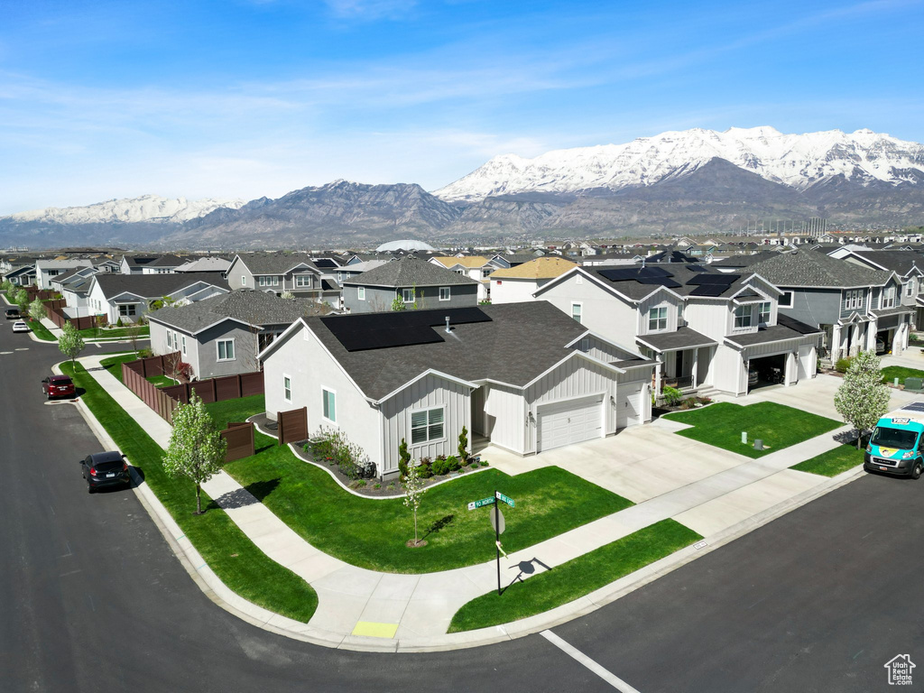 Exterior space with a front yard, a mountain view, and a garage