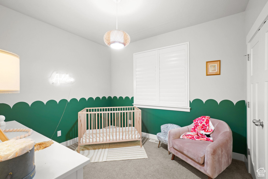Carpeted bedroom with a crib