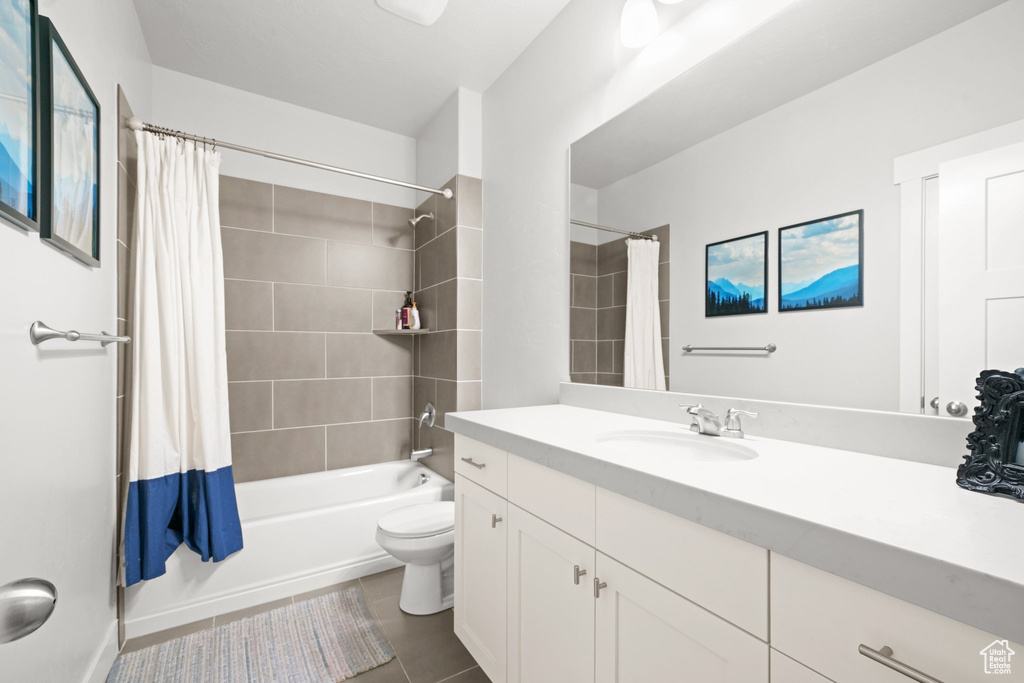 Full bathroom featuring shower / bath combo, oversized vanity, toilet, and tile floors