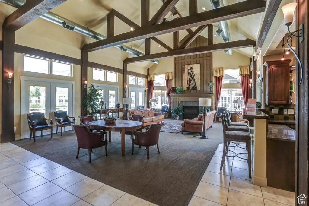 Dining area featuring french doors, beamed ceiling, high vaulted ceiling, and light tile floors