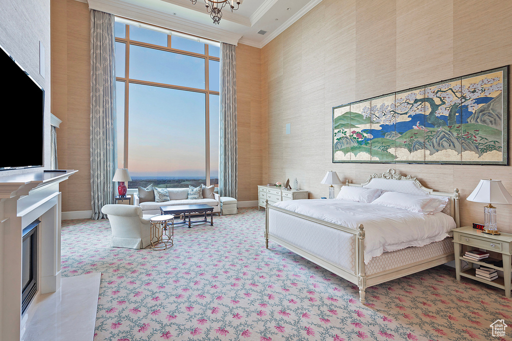 Bedroom with carpet floors, a towering ceiling, and crown molding