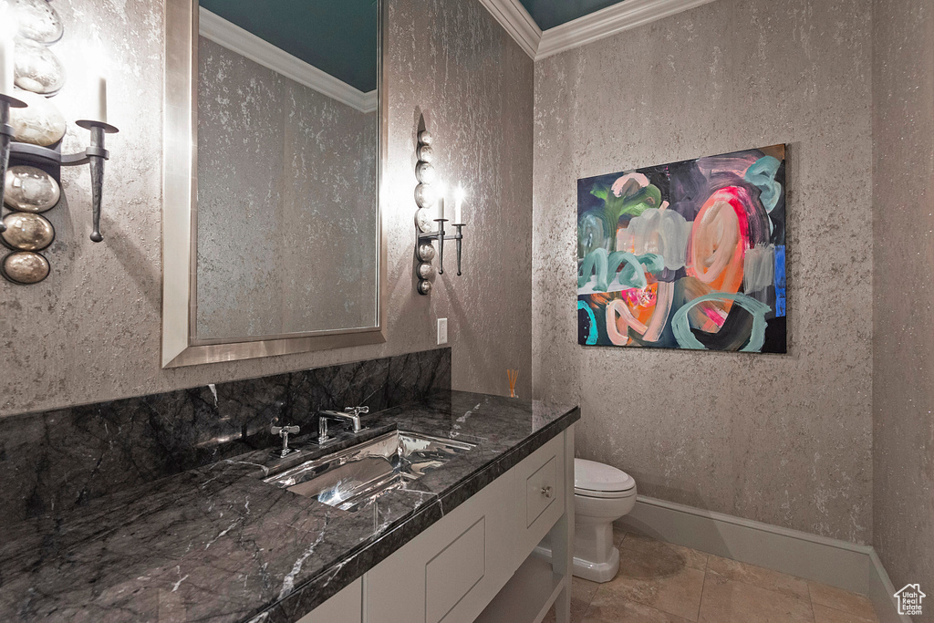 Bathroom with ornamental molding, toilet, tile flooring, and vanity