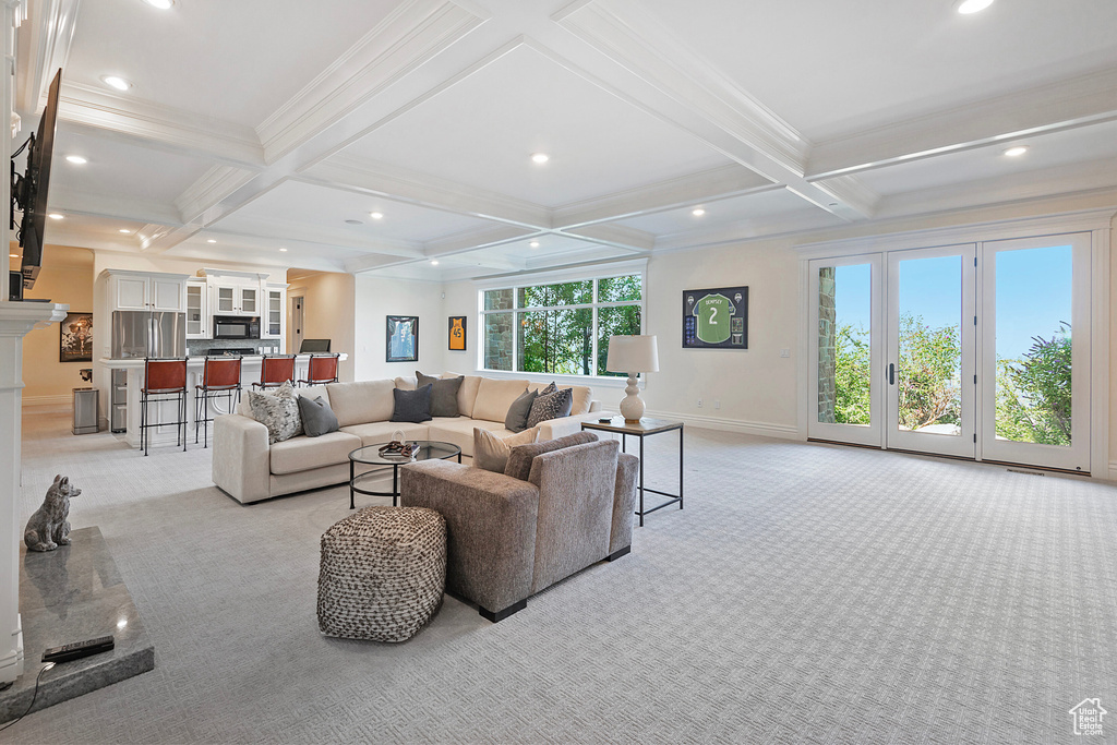 Carpeted living room featuring ornamental molding, coffered ceiling, and beamed ceiling
