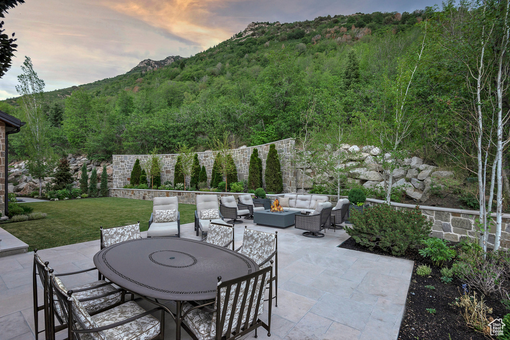 Patio terrace at dusk featuring a mountain view and an outdoor hangout area
