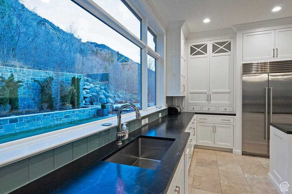 Kitchen featuring sink, built in fridge, tasteful backsplash, and plenty of natural light