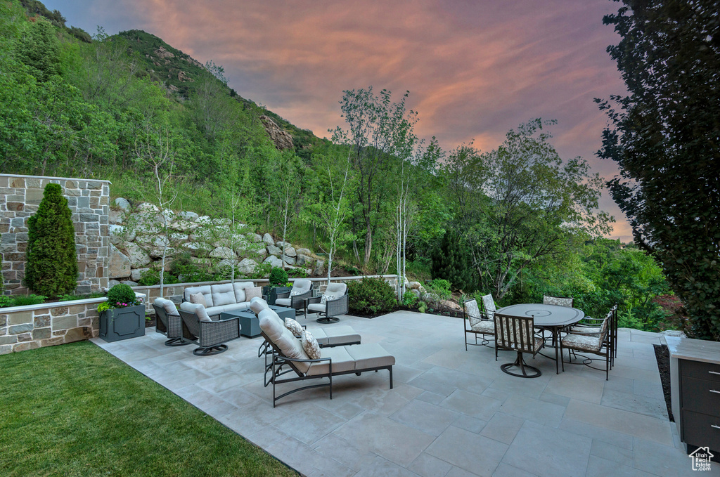 Patio terrace at dusk with a mountain view and outdoor lounge area