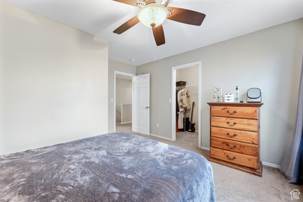 Bedroom featuring a closet, a spacious closet, carpet floors, and ceiling fan