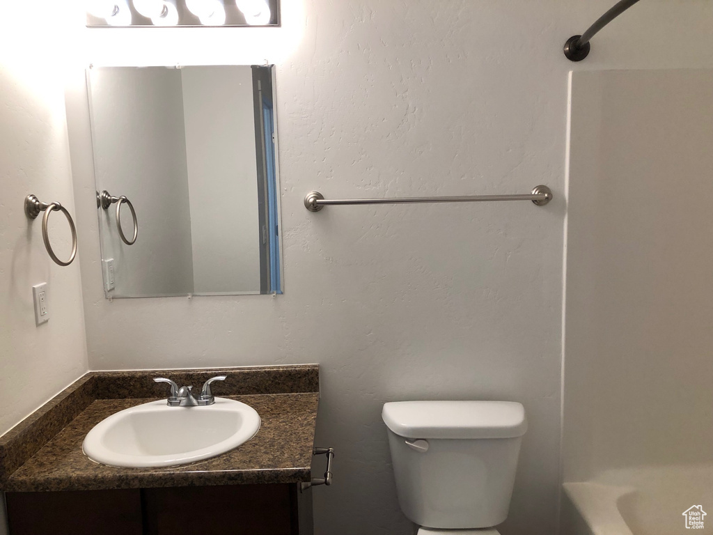 Full bathroom with vanity, bathtub / shower combination, and toilet