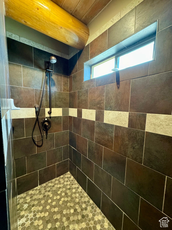 Bathroom featuring wooden ceiling and a tile shower