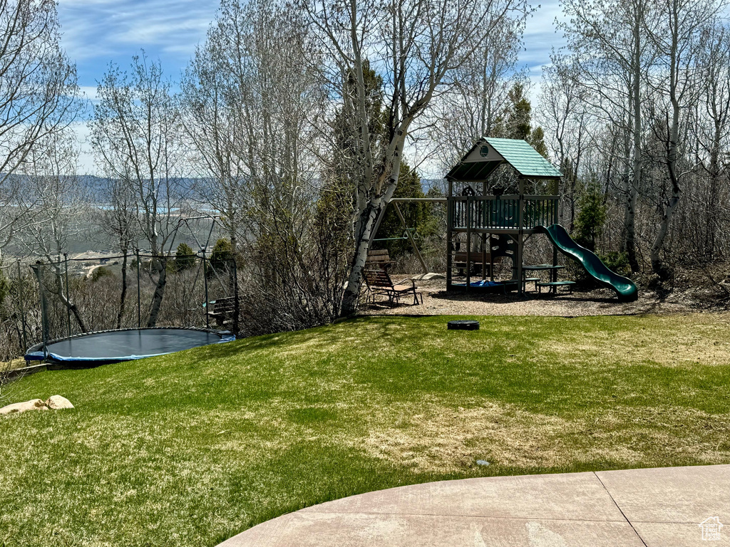 View of jungle gym featuring a trampoline and a yard