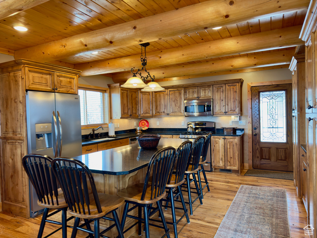 Kitchen with a center island, light hardwood / wood-style flooring, wooden ceiling, stainless steel appliances, and sink