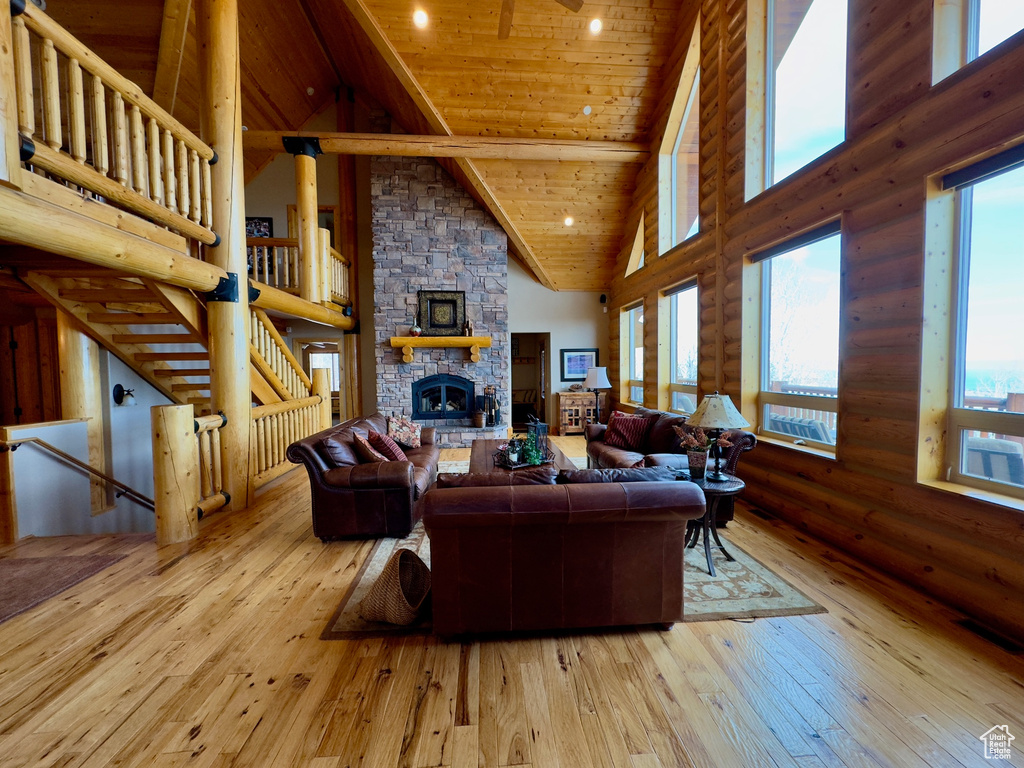 Living room featuring beamed ceiling, a fireplace, high vaulted ceiling, hardwood / wood-style floors, and wooden ceiling