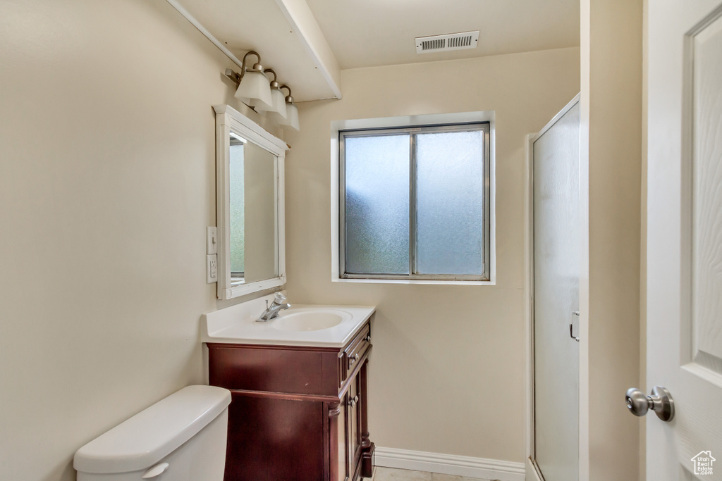 Bathroom featuring vanity, toilet, and a wealth of natural light