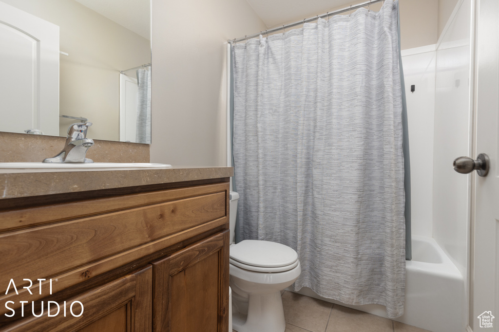 Full bathroom featuring large vanity, shower / bathtub combination with curtain, toilet, and tile flooring