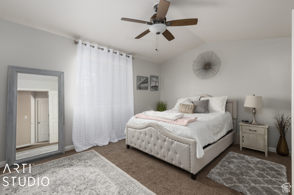Bedroom with lofted ceiling, ceiling fan, and carpet floors