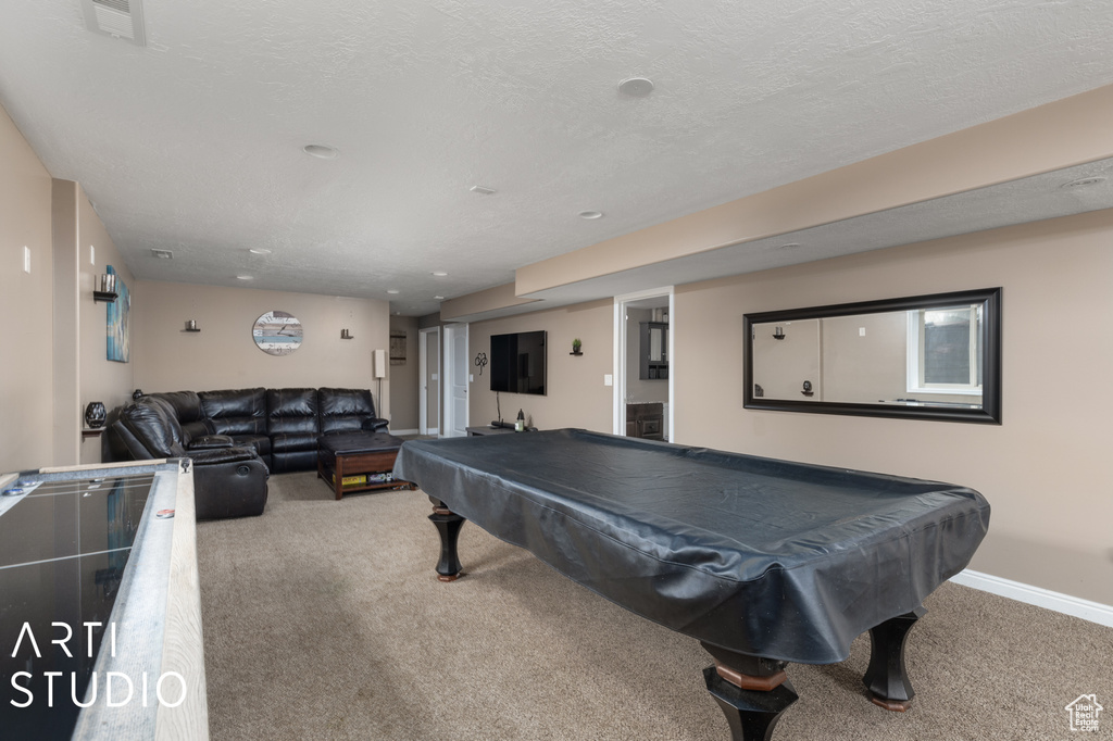 Playroom featuring light carpet, pool table, and a textured ceiling