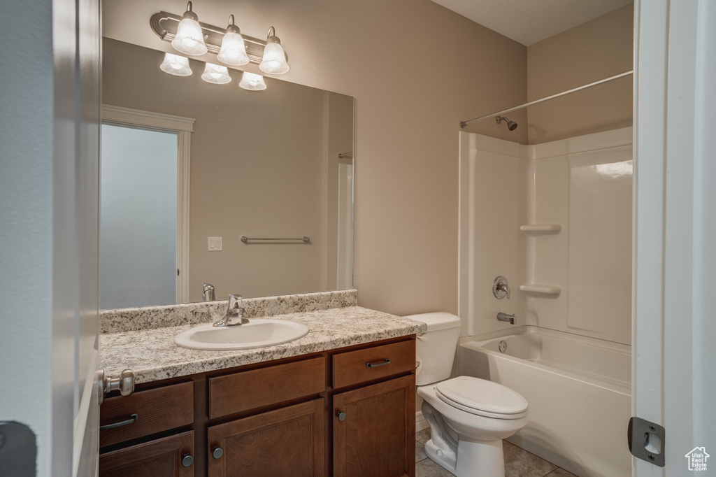 Full bathroom featuring shower / bathtub combination, vanity with extensive cabinet space, toilet, and tile flooring