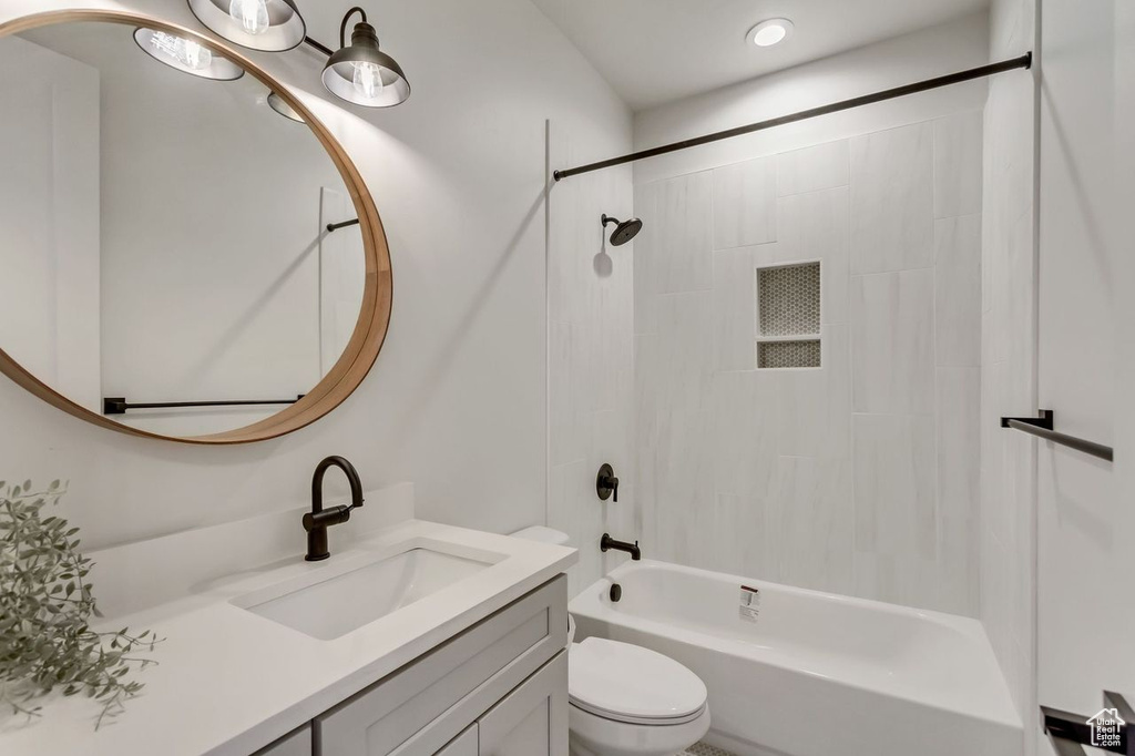 Full bathroom featuring large vanity, toilet, and tiled shower / bath