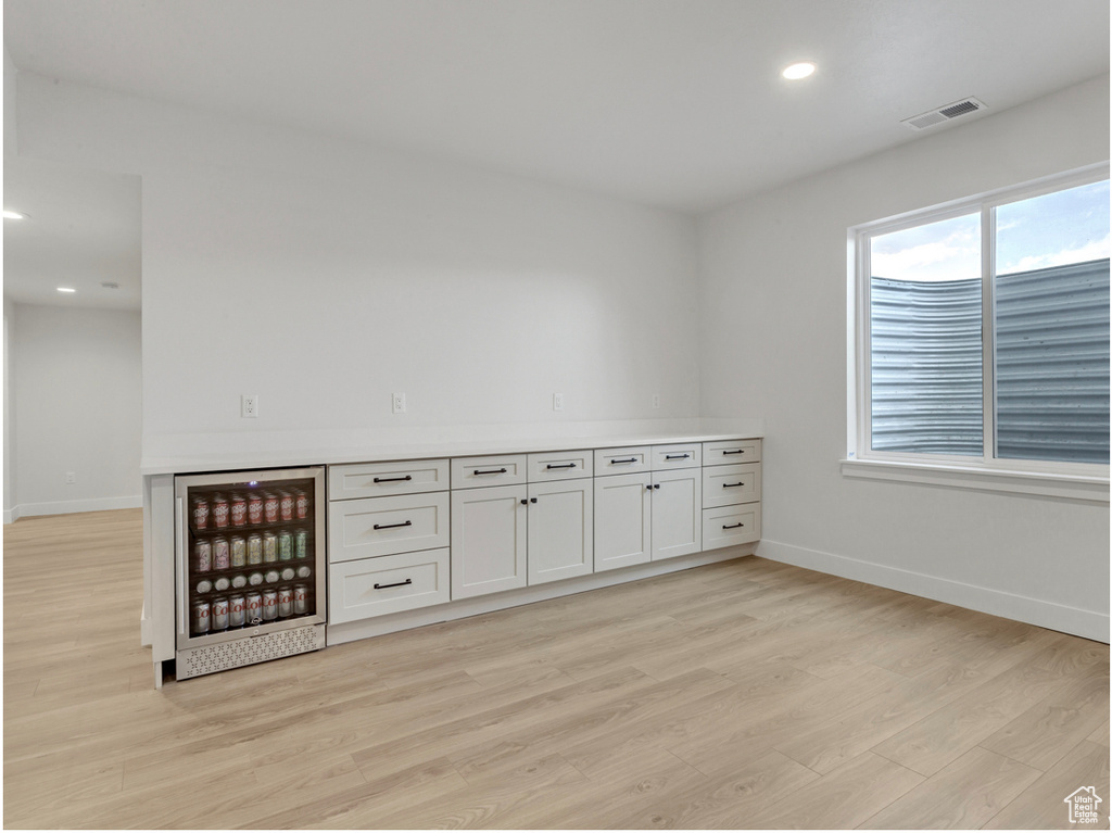 Interior space with light wood-type flooring and beverage cooler