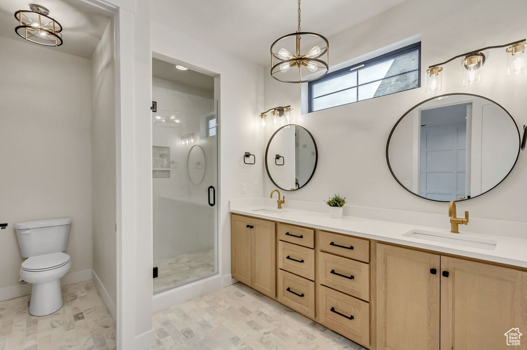 Bathroom with walk in shower, dual bowl vanity, an inviting chandelier, tile flooring, and toilet