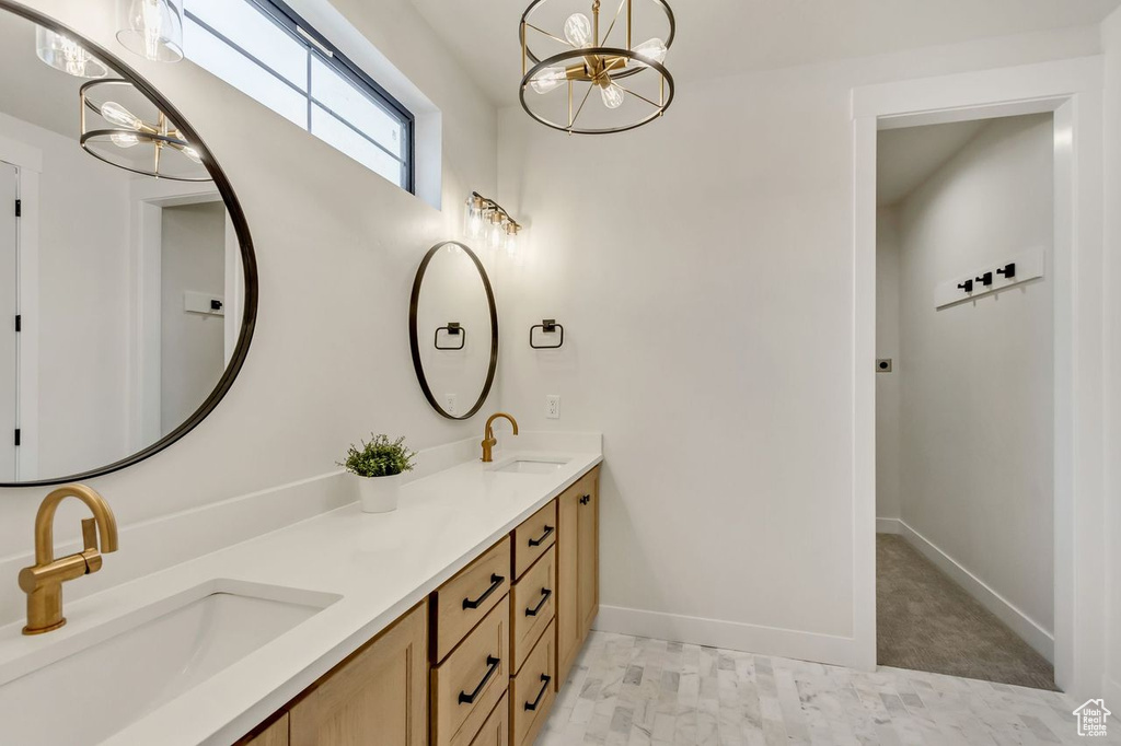 Bathroom with dual bowl vanity and an inviting chandelier