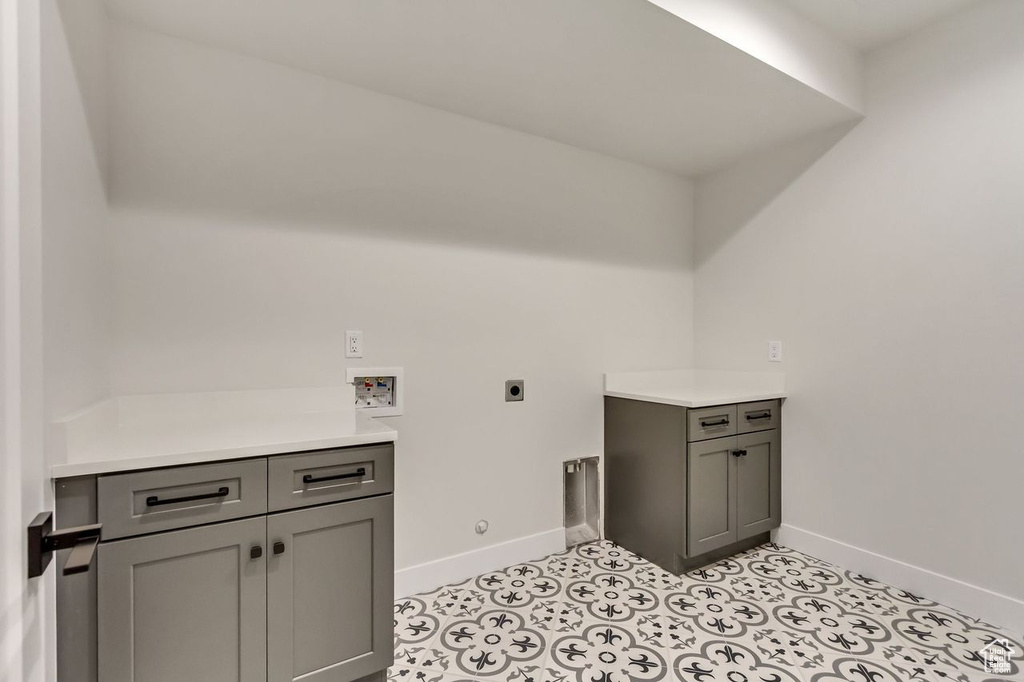 Laundry room with washer hookup, hookup for an electric dryer, cabinets, and light tile flooring
