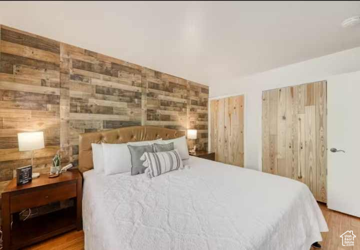 Bedroom featuring hardwood / wood-style floors and wooden walls