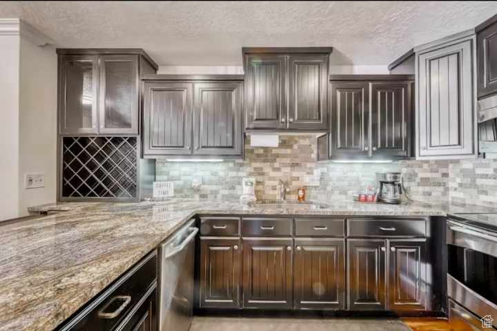 Kitchen featuring tasteful backsplash, appliances with stainless steel finishes, and dark brown cabinetry