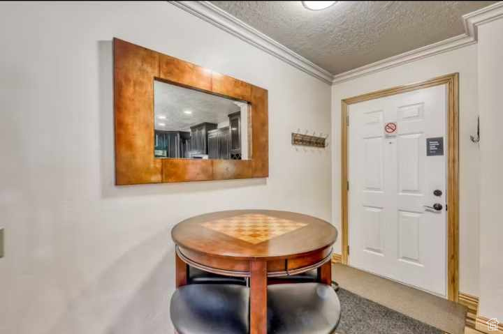 Entrance foyer with a textured ceiling and ornamental molding