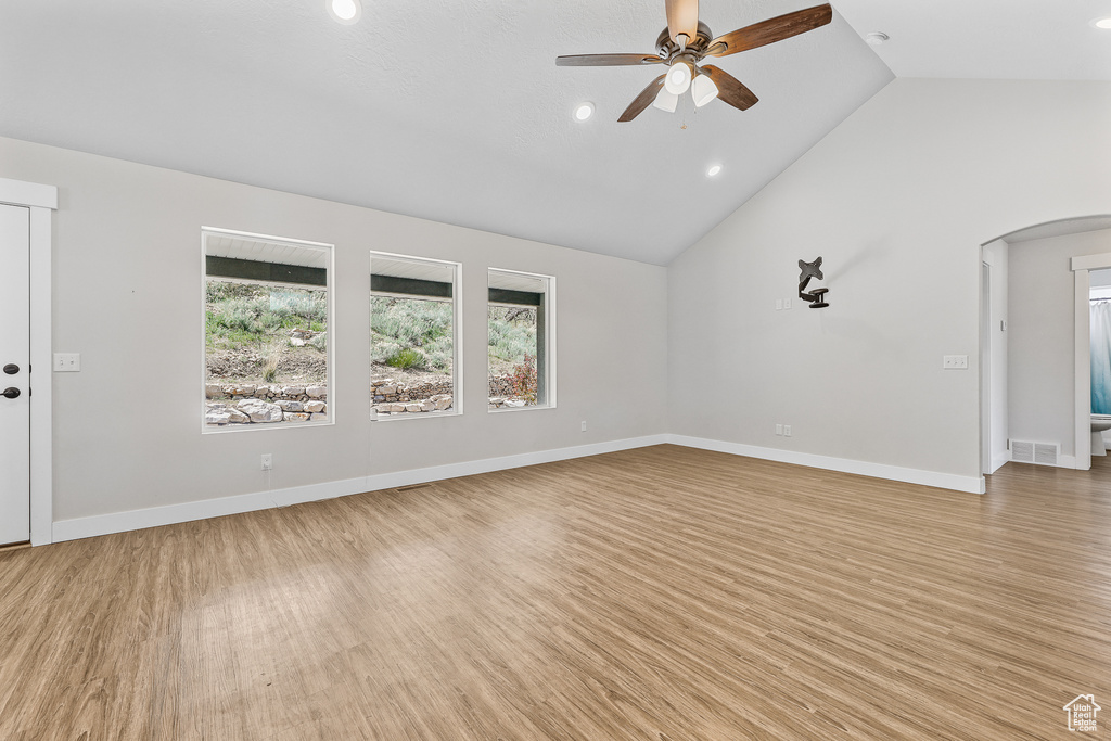 Unfurnished room with high vaulted ceiling, ceiling fan, and light wood-type flooring