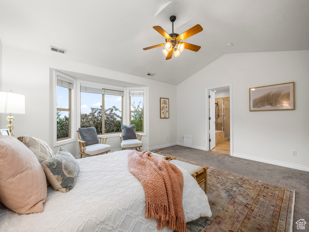 Bedroom featuring light colored carpet, vaulted ceiling, ceiling fan, and connected bathroom