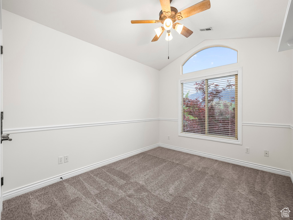 Unfurnished room with vaulted ceiling, ceiling fan, and carpet floors