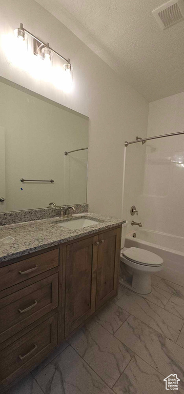 Full bathroom with toilet, tile flooring, a textured ceiling, vanity, and washtub / shower combination
