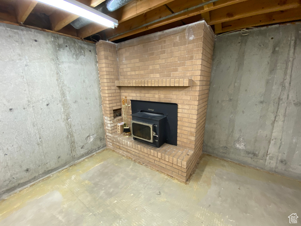 Unfurnished living room featuring concrete floors and a wood stove