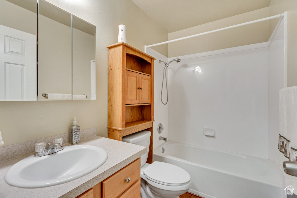 Full bathroom featuring toilet, vanity, and bathing tub / shower combination