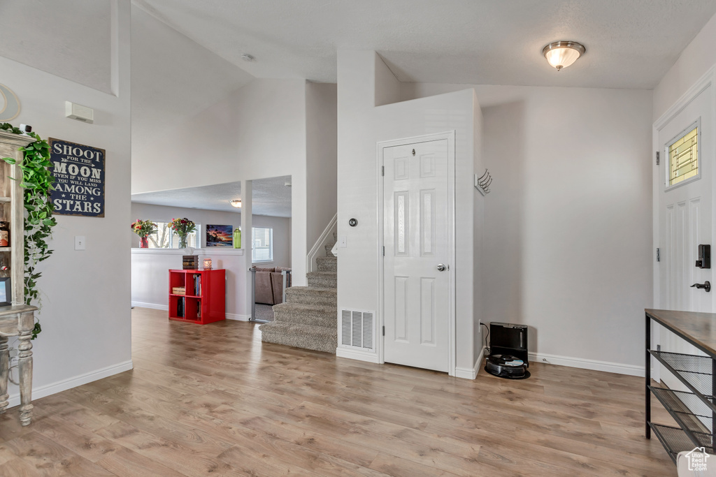 Entryway featuring high vaulted ceiling and light hardwood / wood-style floors